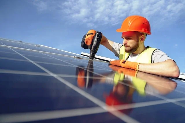 un technicien installe des panneaux solaires 