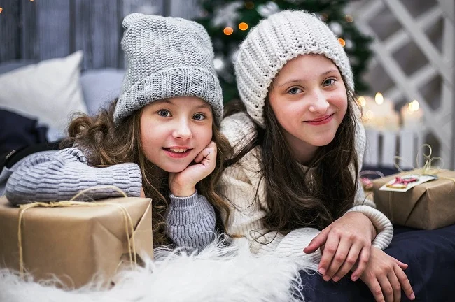 deux fillettes avec des cadeaux de noel autour 