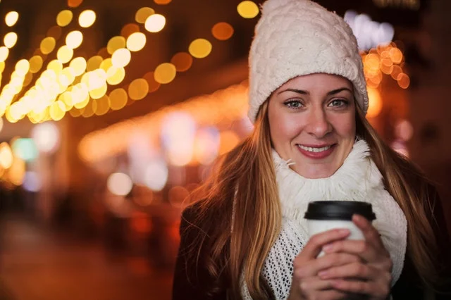 une jeune femme tient un mug de café chaud